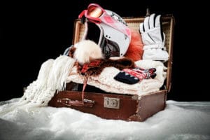 A suitcase full of luggage and items for skiing in Colorado.