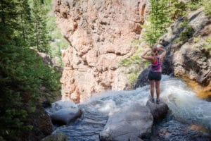 A young woman hikes to a water fall during a quintessential Vail summer.