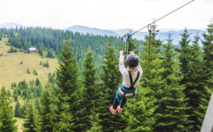 Photo of a person taking one of the Colorado zipline tours over forest canopy