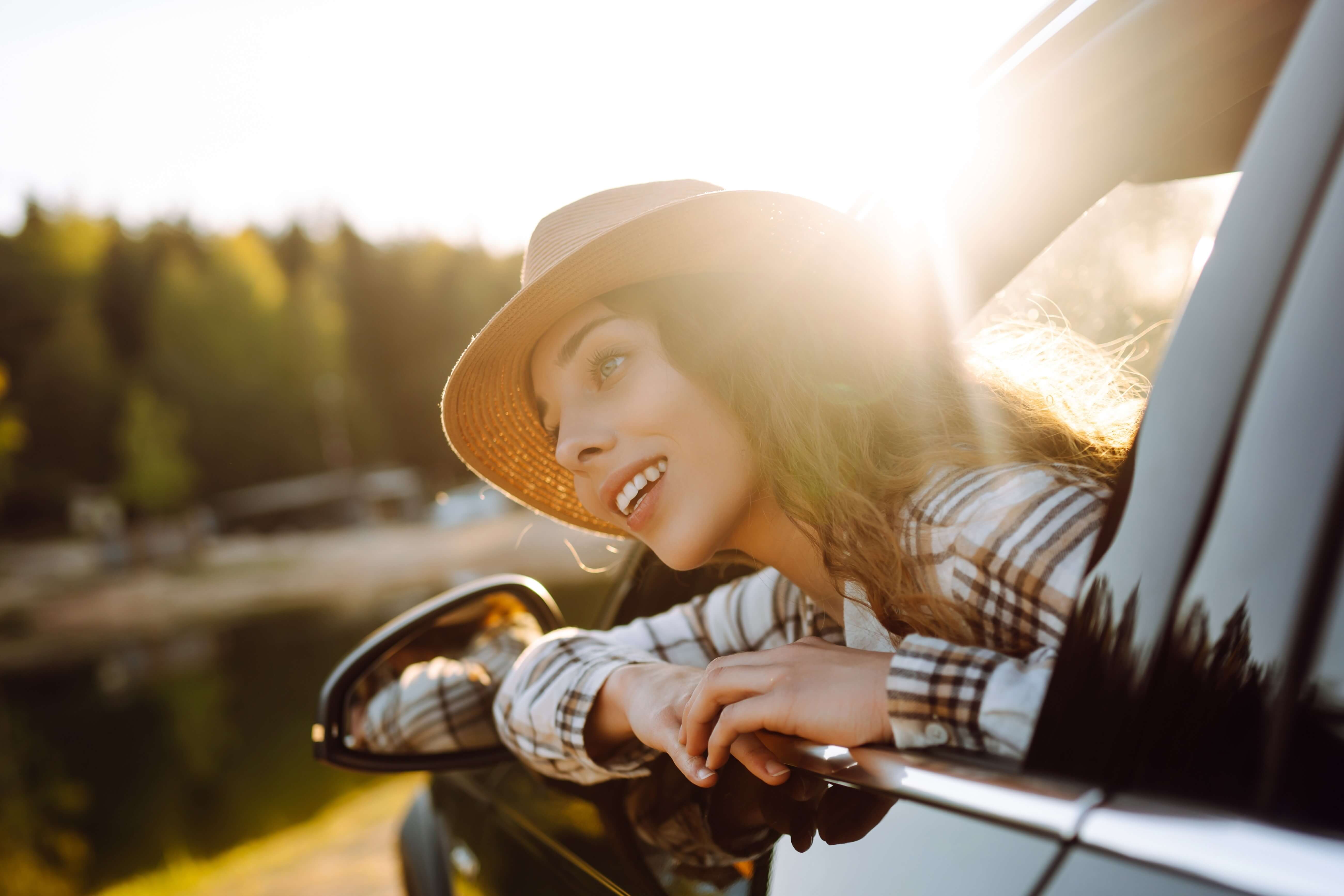 A woman looking at Roadside Attractions out of a car window.
